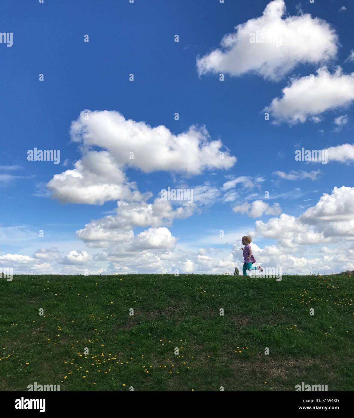 Running child on a hill Stock Photo