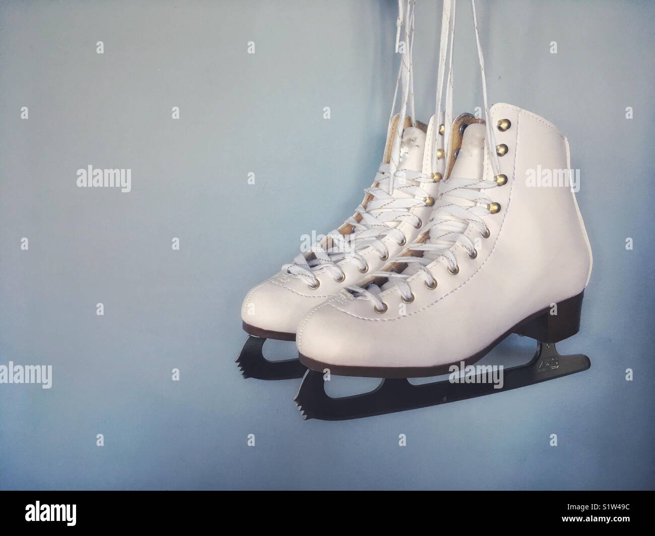 Ladies ice skates against plain background. Copy / text space. - Smartphone Captured Stock Image