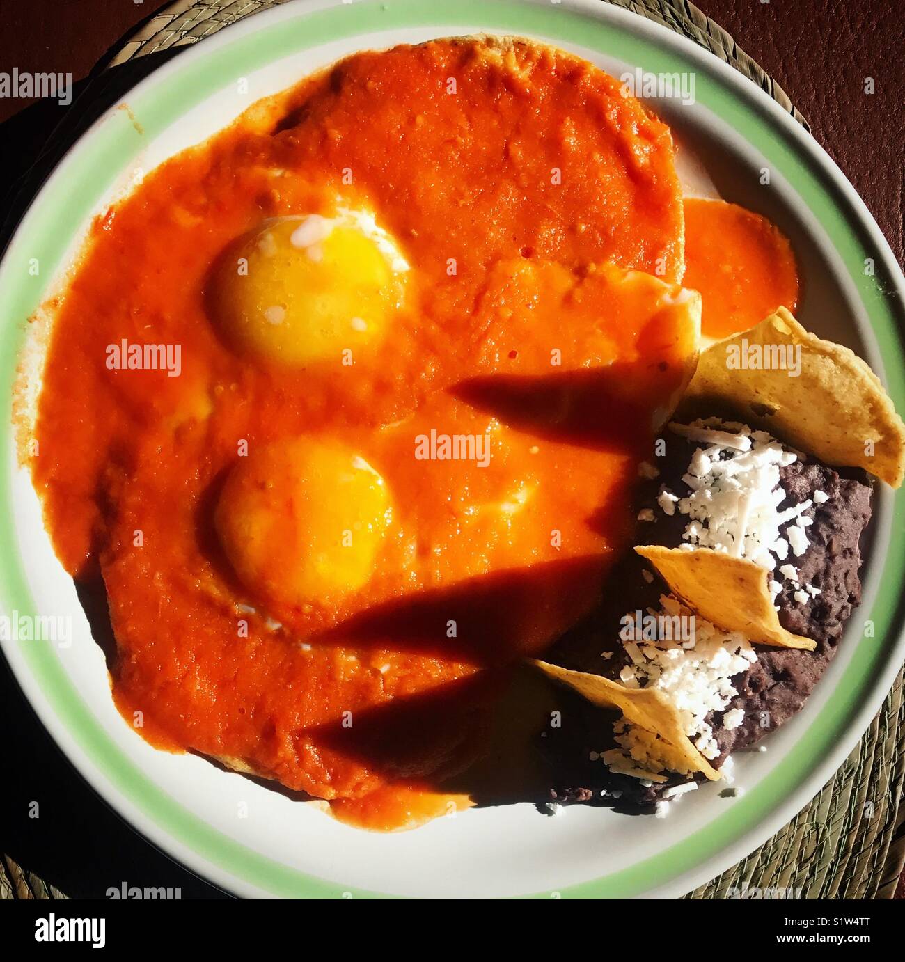 Eggs in red tomatoe sauce with black beans in a restaurant in Mexico City - Smartphone Captured Stock Image
