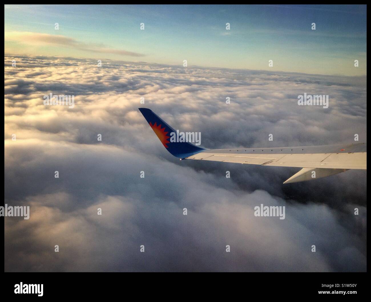 Sunrise above the clouds as seen from a Jet2 flight en-route to Spain. - Smartphone Captured Stock Image