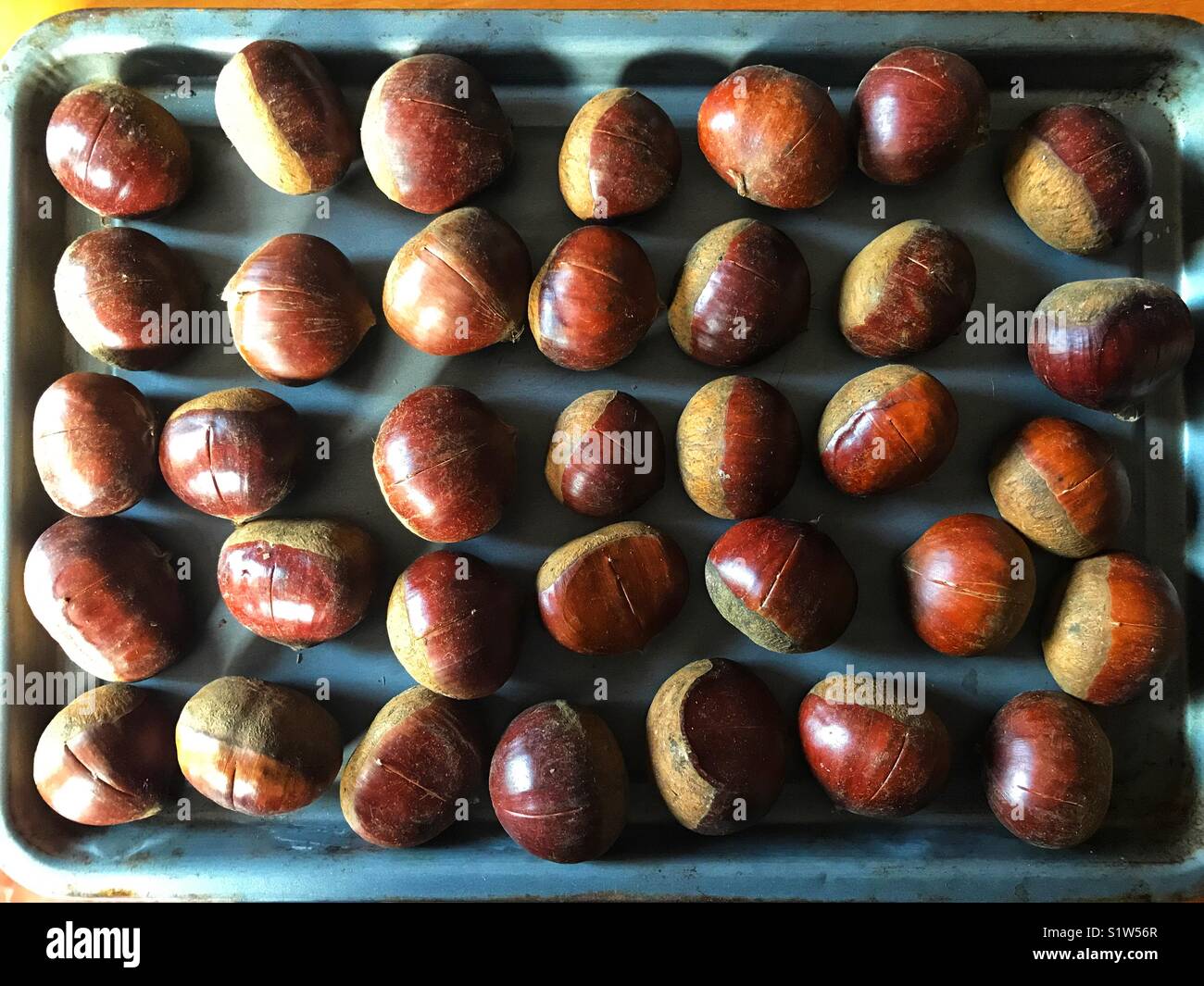 Chestnuts in a baking tray ready to be roasted in the oven - Smartphone Captured Stock Image