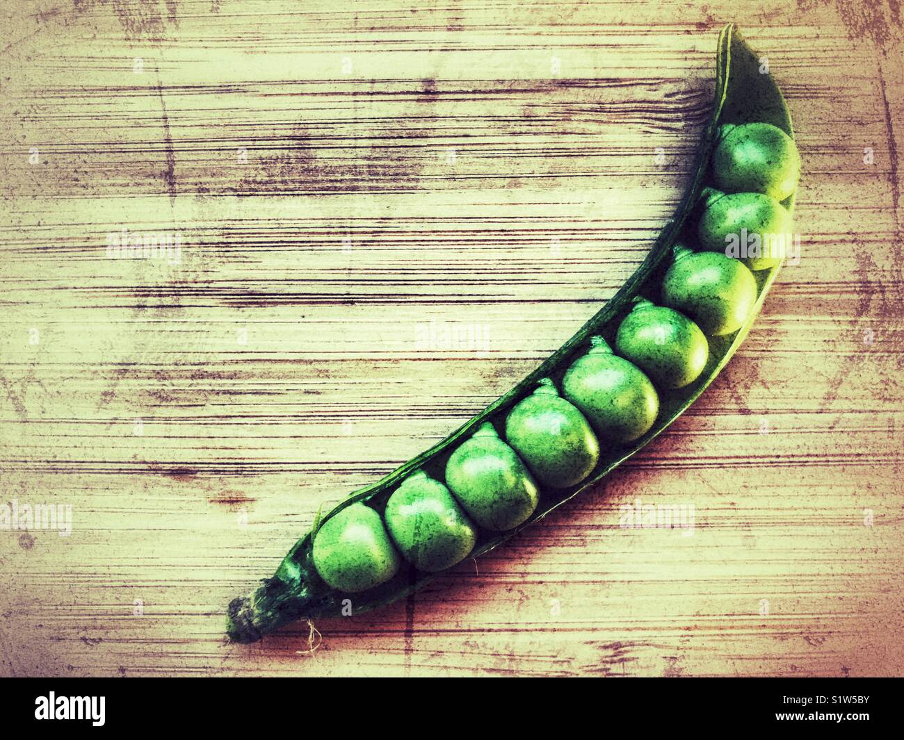 Fresh green peas in a pod on a bamboo board with copy space - Smartphone Captured Stock Image