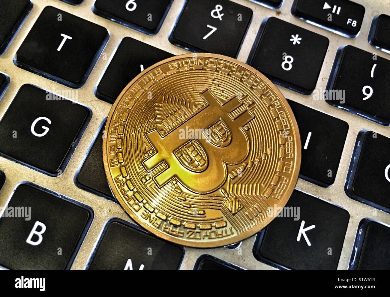 A bitcoin on a computer keyboard - Smartphone Captured Stock Image