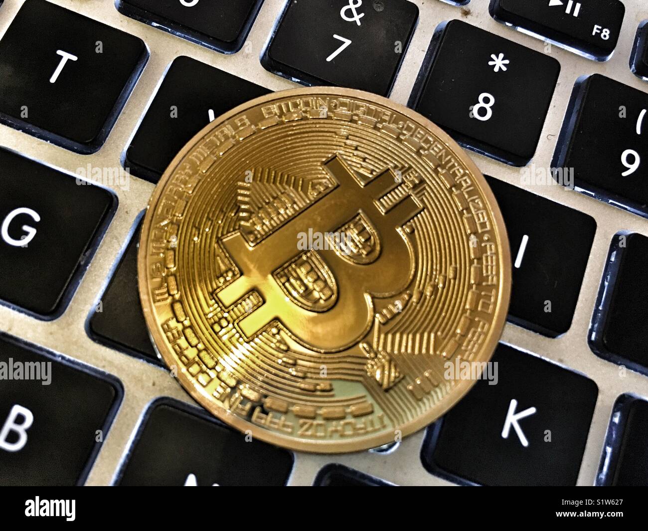 A bitcoin on a computer keyboard - Smartphone Captured Stock Image