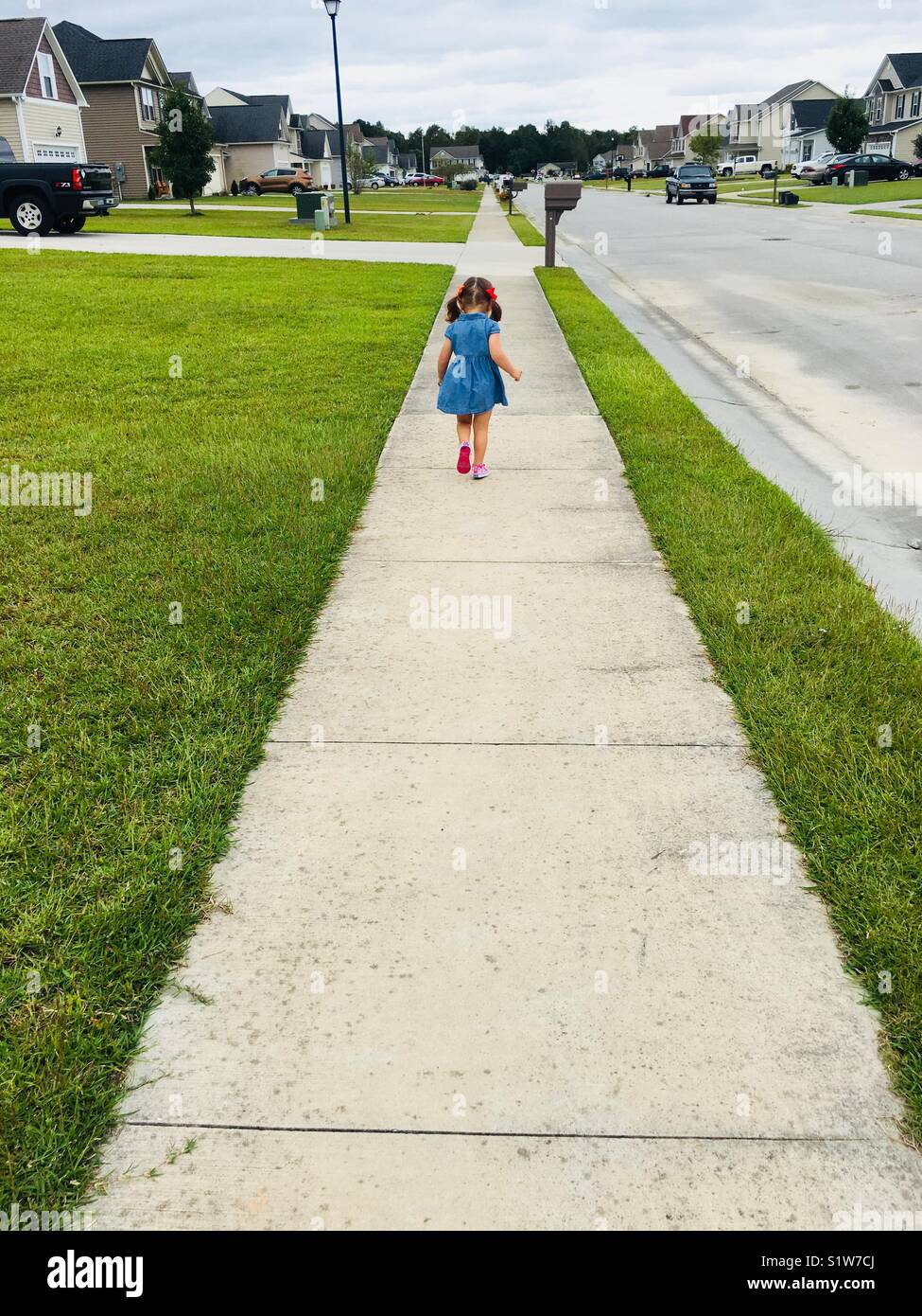 Little girl running down sidewalk Stock Photo Alamy