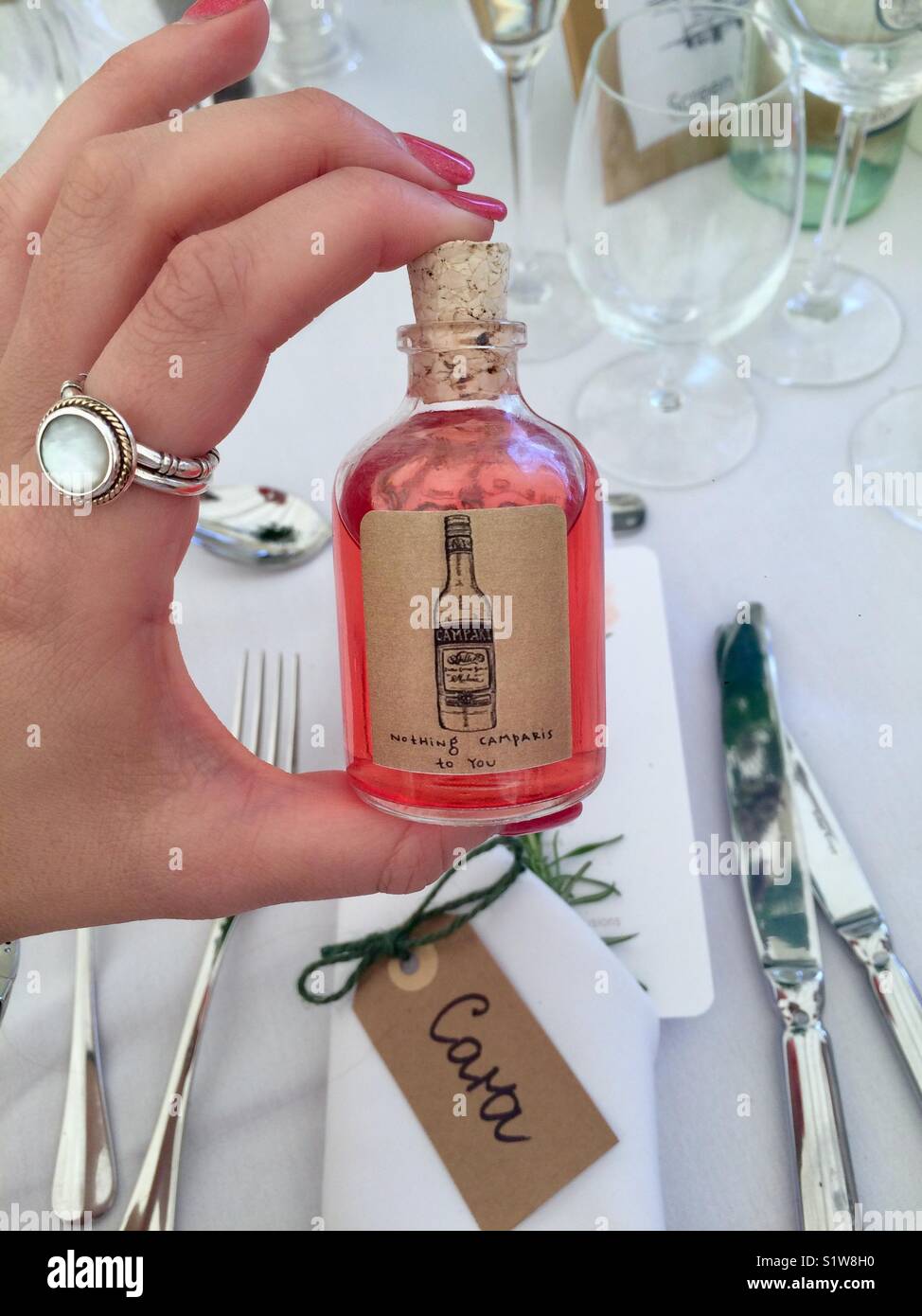 Mini bottle of Campari held in hand as wedding favour Stock Photo