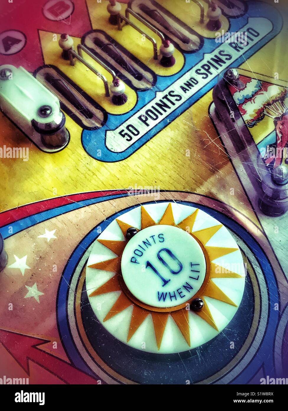 Top down view of a colorful playing field of a vintage pinball machine. - Smartphone Captured Stock Image