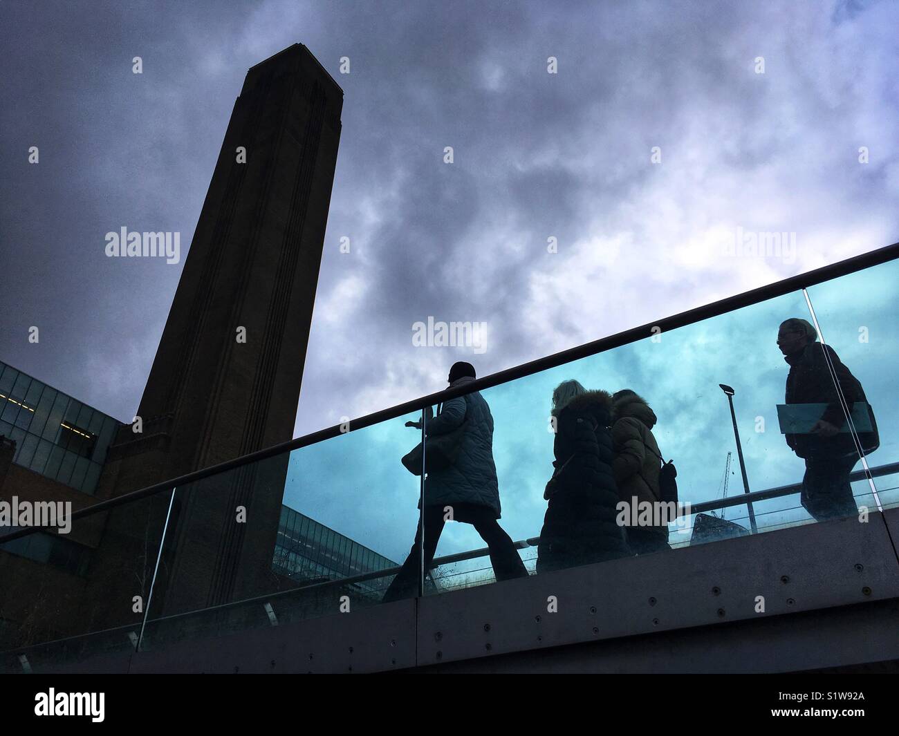 People walk across the Millennium bridge by Tate Modern in London,  England on January 1 2018 - Smartphone Captured Stock Image
