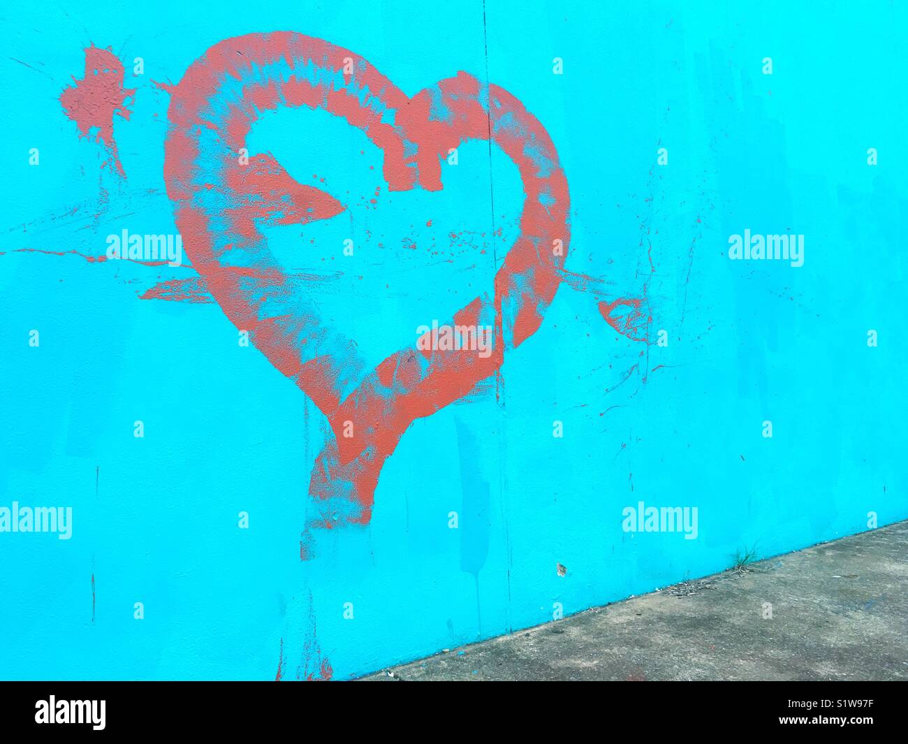 Graffiti depicting a heart painted on a blue wall. - Smartphone Captured Stock Image