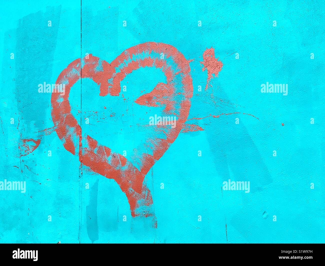 Graffiti depicting a heart painted on a blue wall. Stock Photo