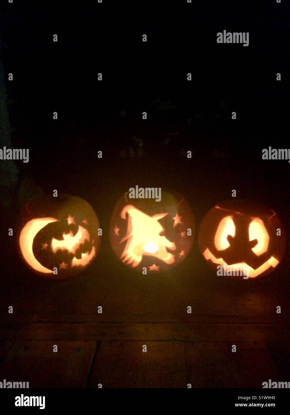Three Halloween pumpkins in a row Stock Photo - Alamy