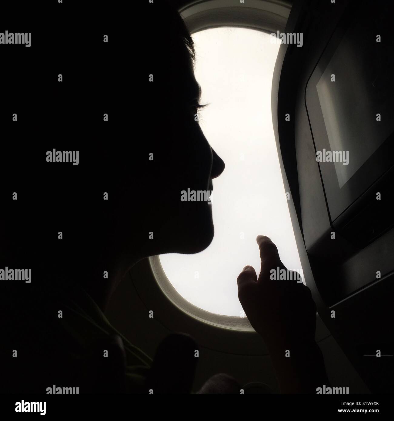 Child looking out the window on an airplane - Smartphone Captured Stock Image