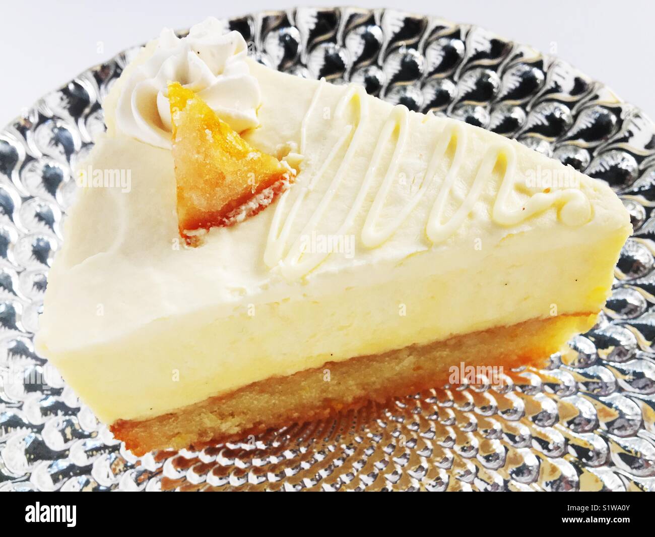 Slice of decadent mousse cake on a silver platter and white background. Stock Photo