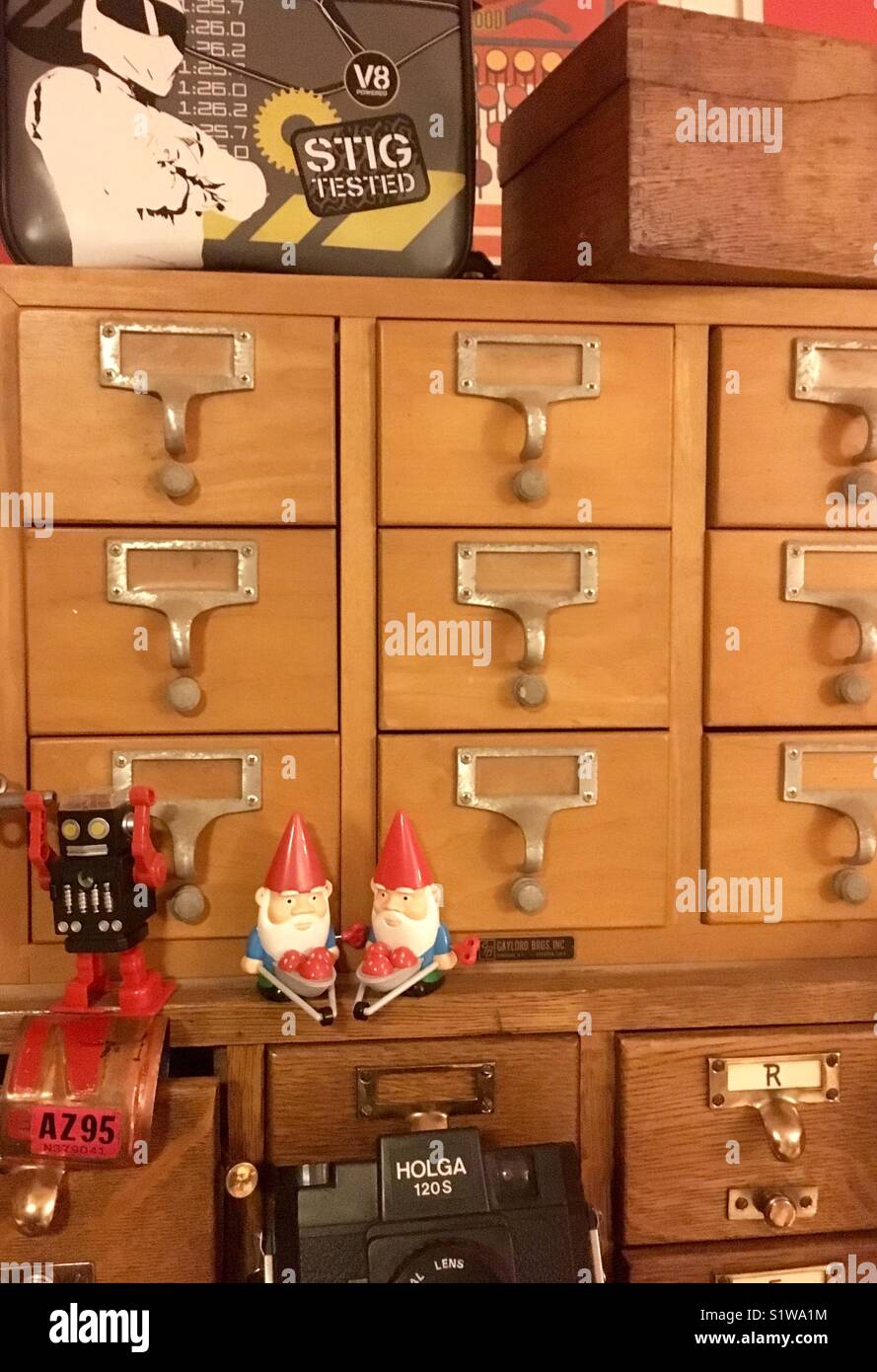 Vintage library card catalog cabinet with gnomes vintage holga camera and toy robot Stock Photo