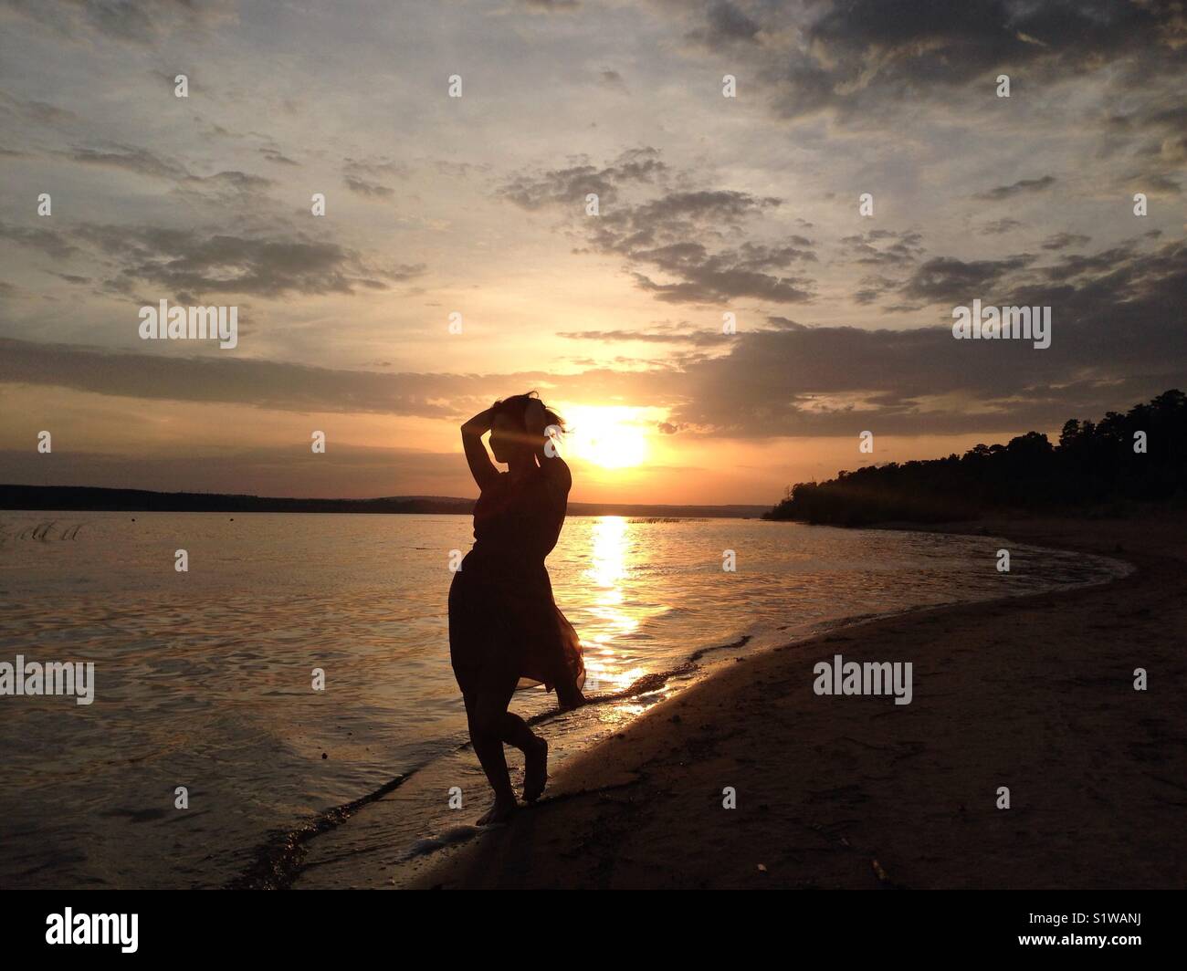 Girl silhouette at sunset near Volga river Stock Photo