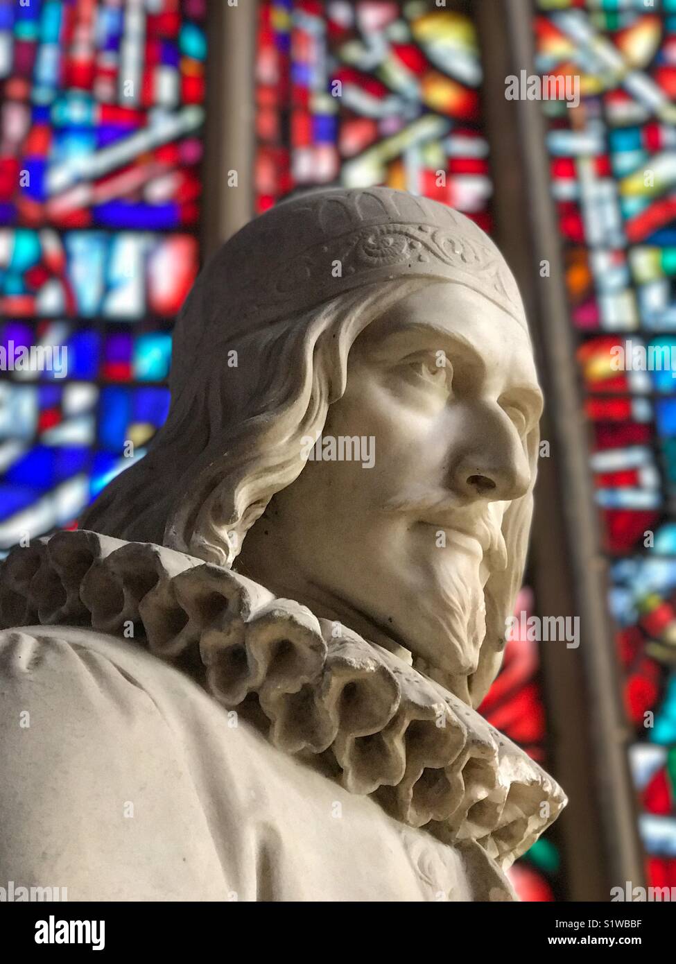 Statue of English historic figure against a stained glass background. Head & shoulder shot. Stock Photo