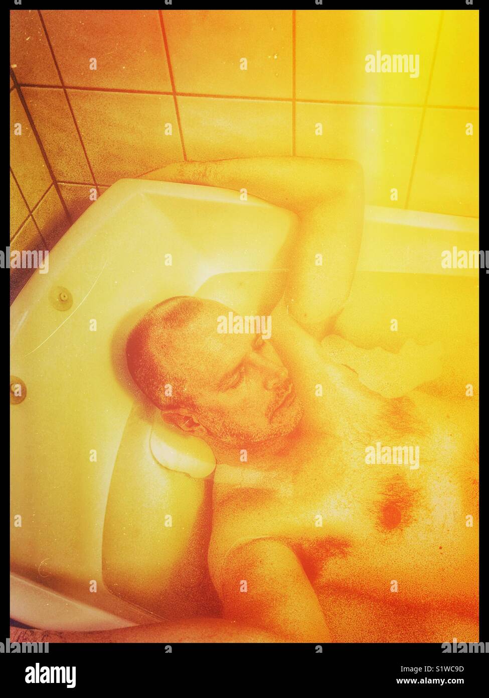 Middle aged Scandinavian man asleep in the bath Stock Photo