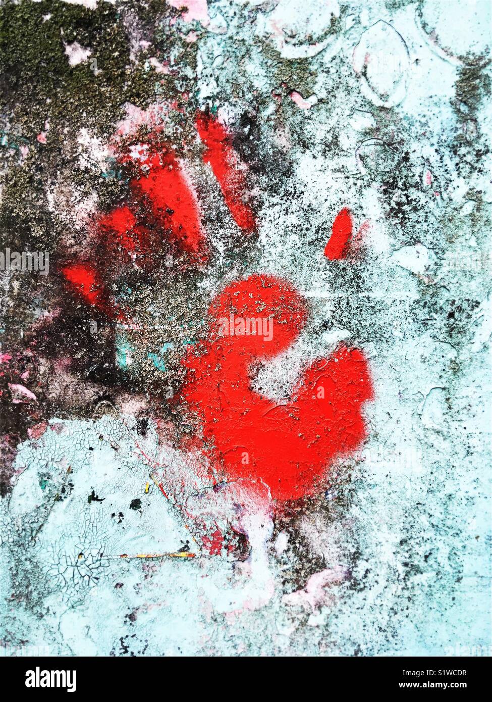 A faint red hand print on a grungy wall Stock Photo