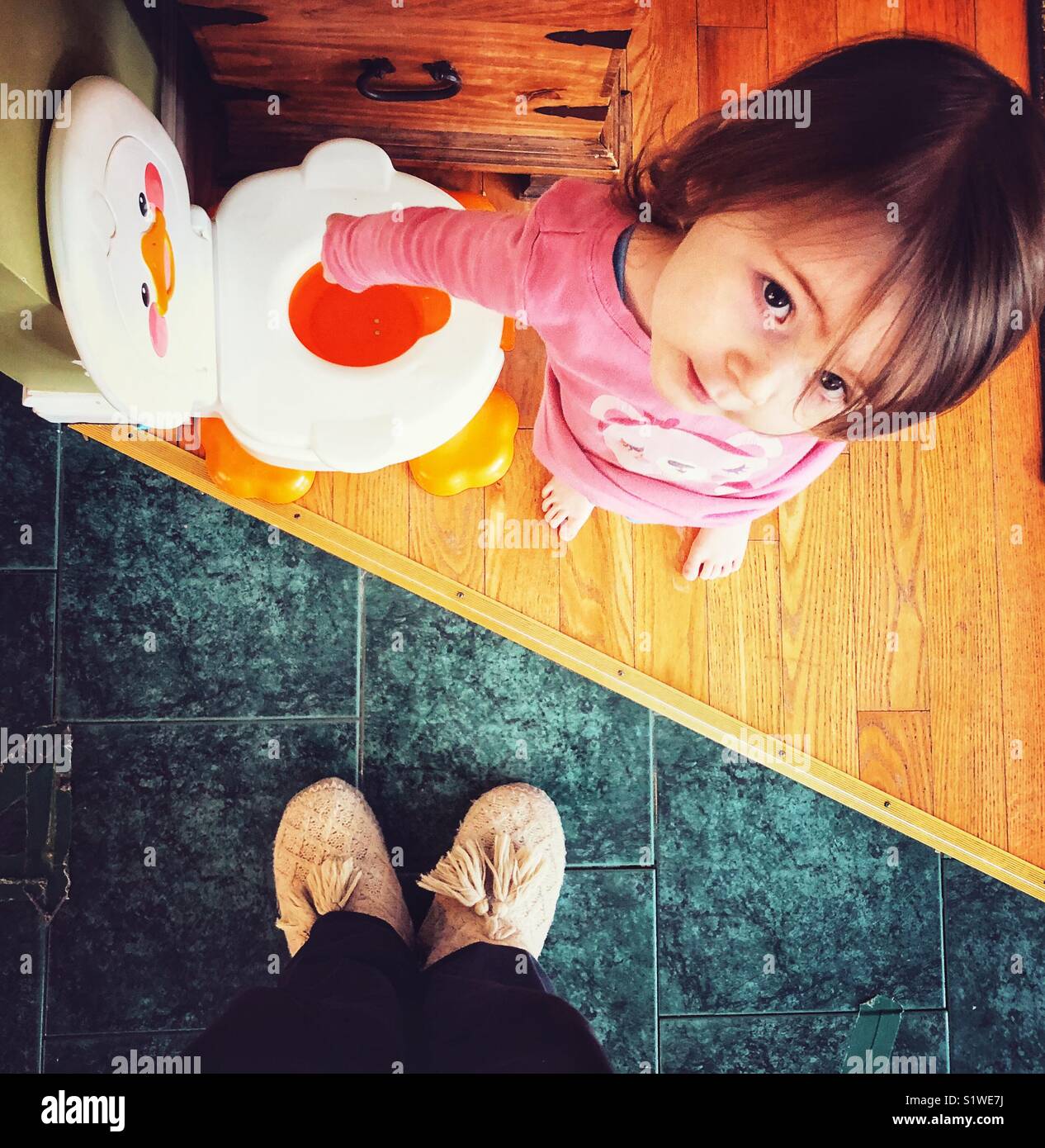 From above parent’s view of 2 year old toddler girl showing off success