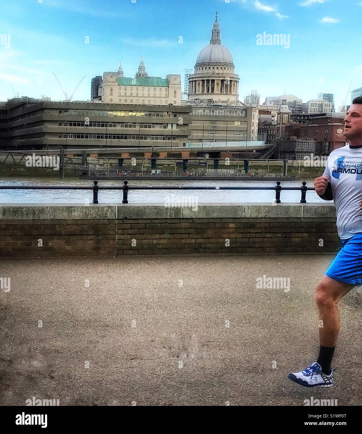 Half Marathon Man ...A jogger on Southbank of the river Thames with St Paul’s Cathedral in the background - Smartphone Captured Stock Image