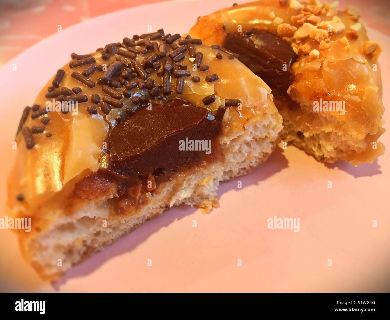 A peanut butter and chocolate donut cut in half. Stock Photo