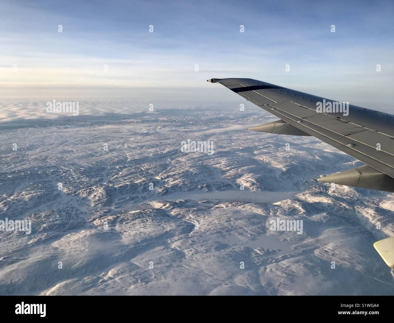 Airplane flying over Canadian Arctic tundra and ice Stock Photo