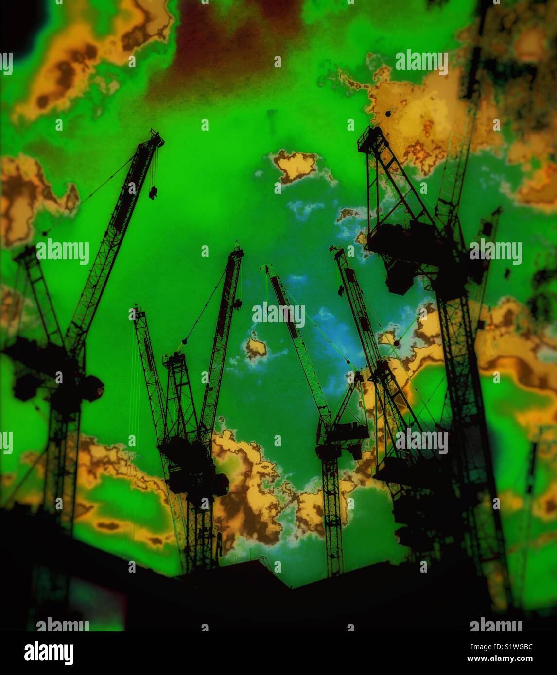 Artistic rendering of a sea of cranes towering upwards into a surreal green sky Stock Photo