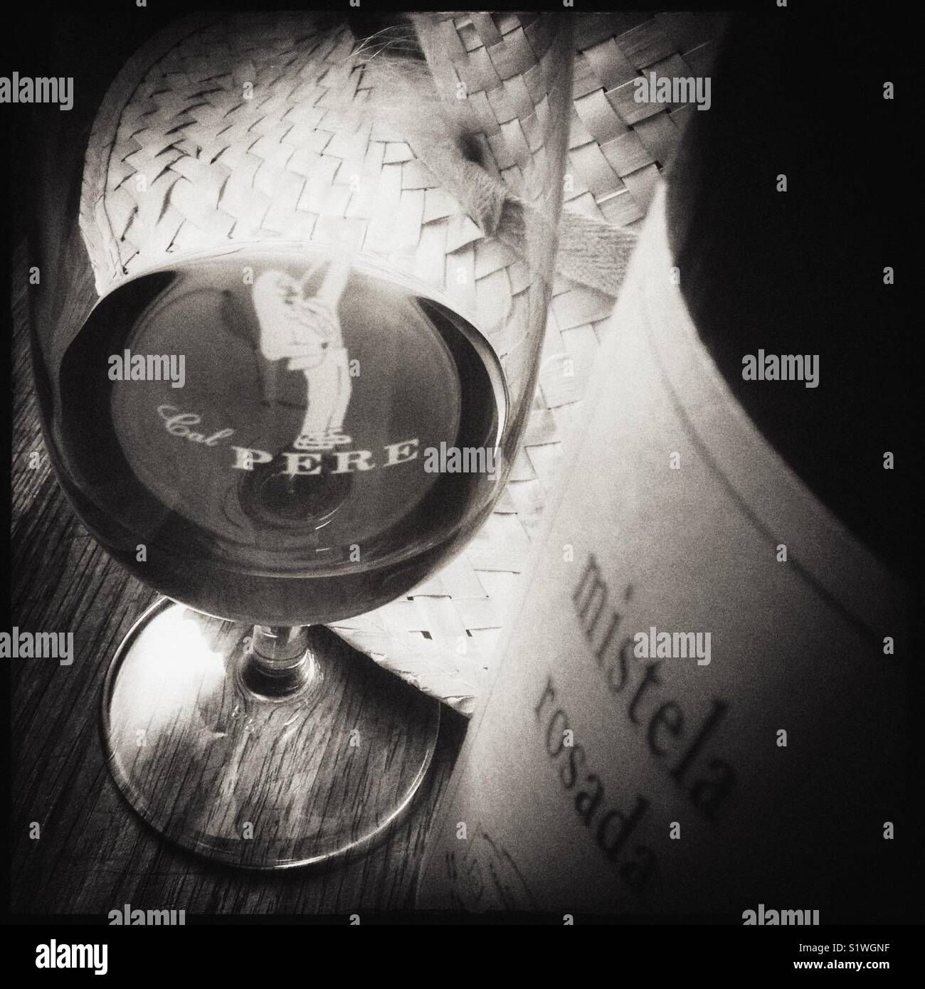 A glass of Mistela Rosada with bottle. Mistela is a local, traditional sweet fortified grape liquor made from maceration without fermentation. - Smartphone Captured Stock Image