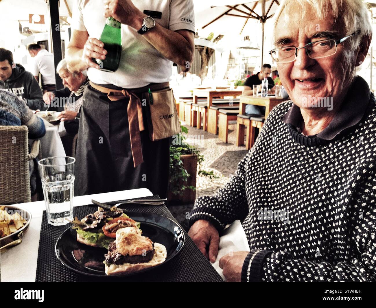 Senior man ready to eat his meal at the Apolo cafe restaurant in Funchal, Madeira, Portugal - Smartphone Captured Stock Image