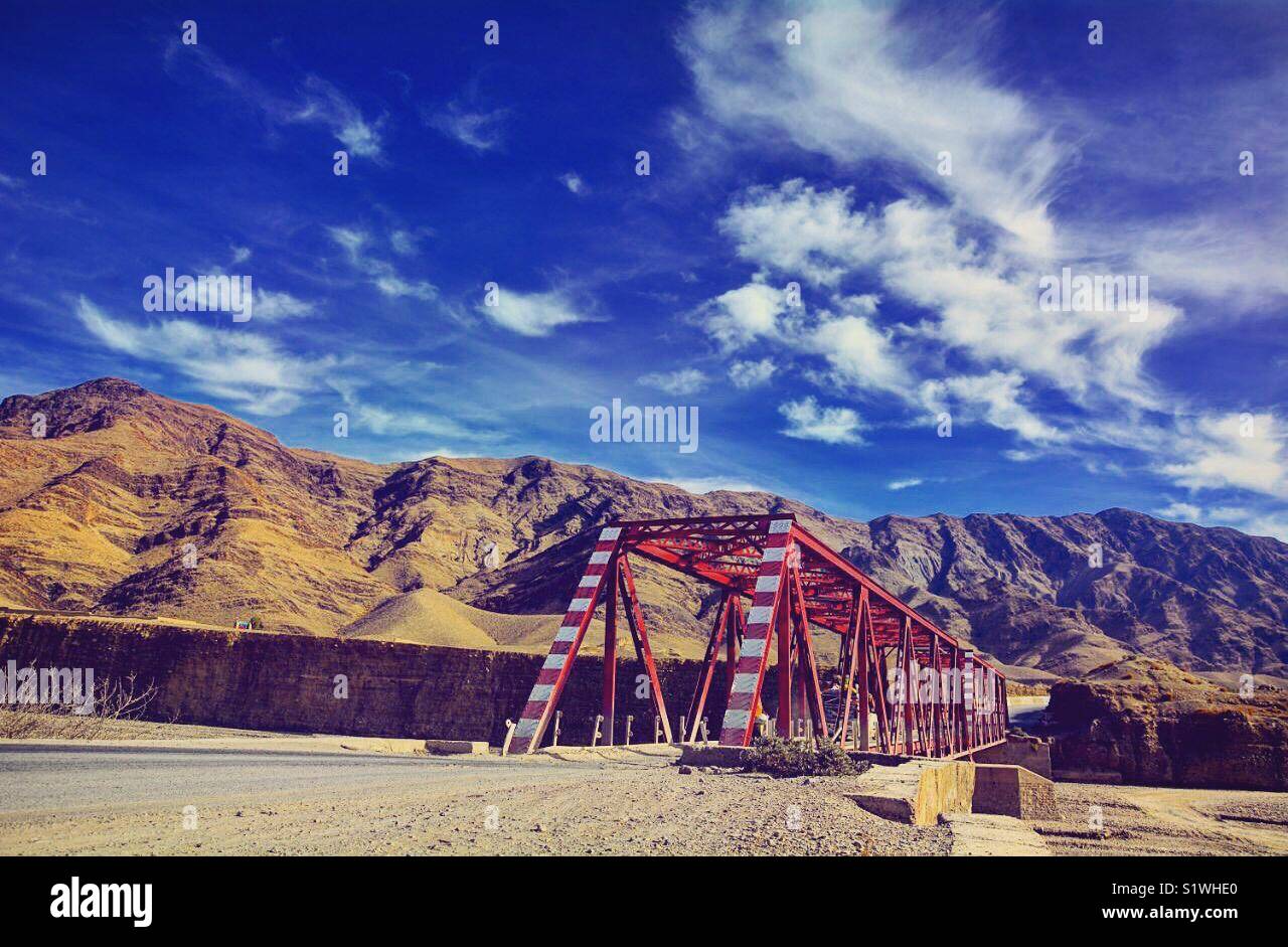 The Red bridge. A connecting bridge between two cities. Captured by a travel photographer while he is traveling around southern area of Pakistan. Some people call this area tribal area of Pakistan. Stock Photo