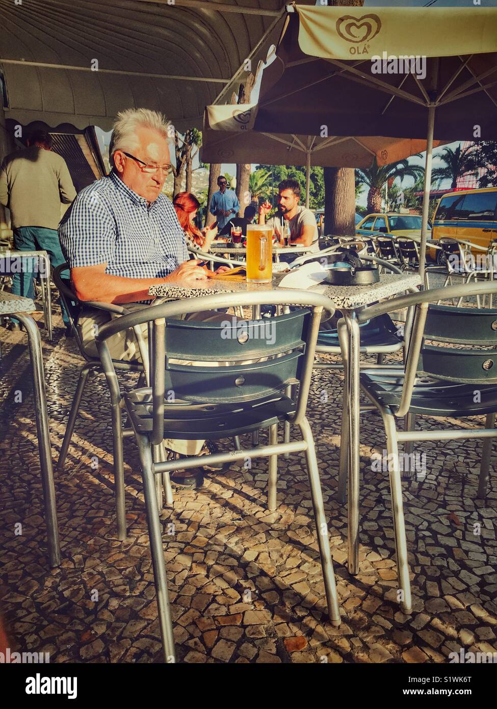 Cafe scene. Senior man with a beer at an outdoor cafe in Funchal, Madeira, Portugal Stock Photo