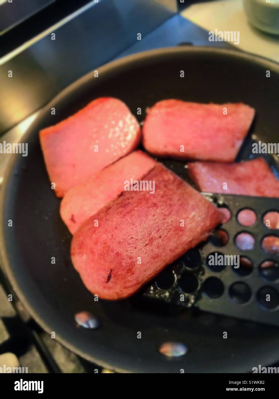 Skillet frying spam slices and spatula, United States. - Smartphone Captured Stock Image