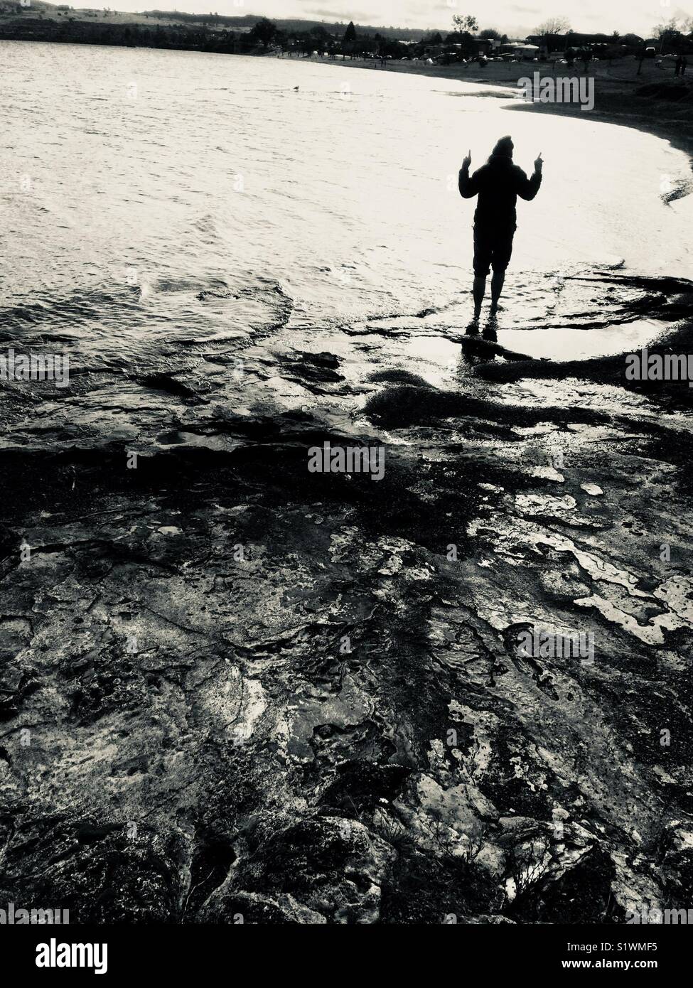 Girl standing in water holding up hands. Stock Photo