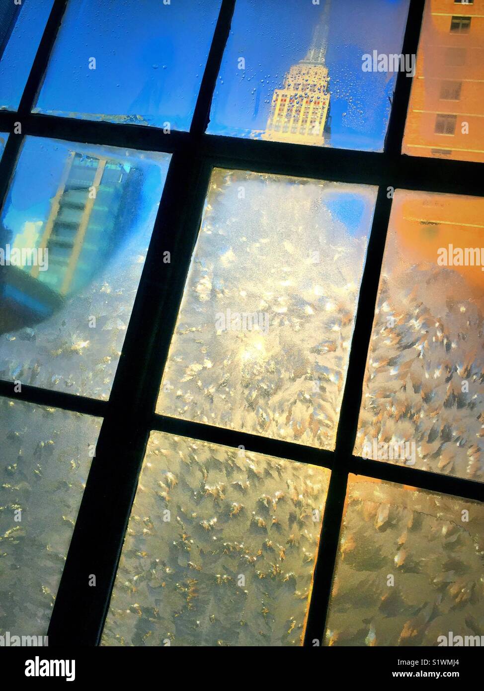 View of the Empire State building from New York City apartment with ice encrusted casement window, USA - Smartphone Captured Stock Image