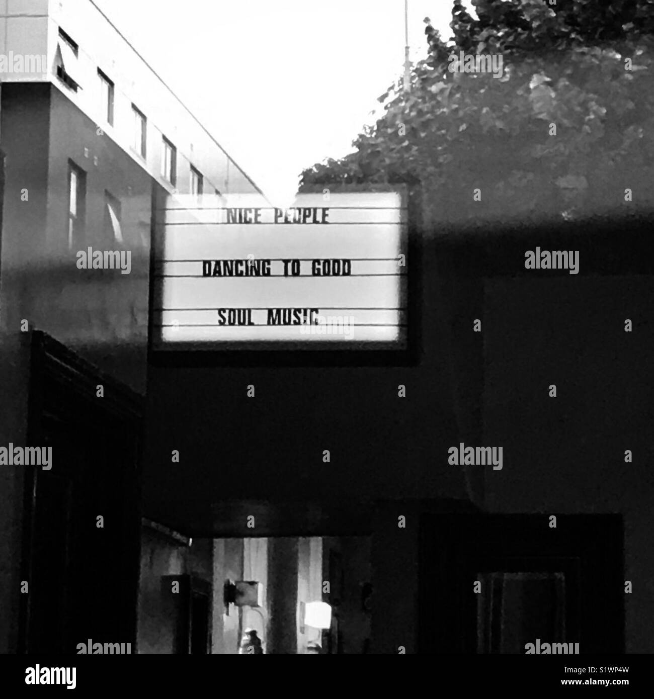 ‘Nice People Dancing to Good Soul Music’ light box sign in window with reflection Stock Photo