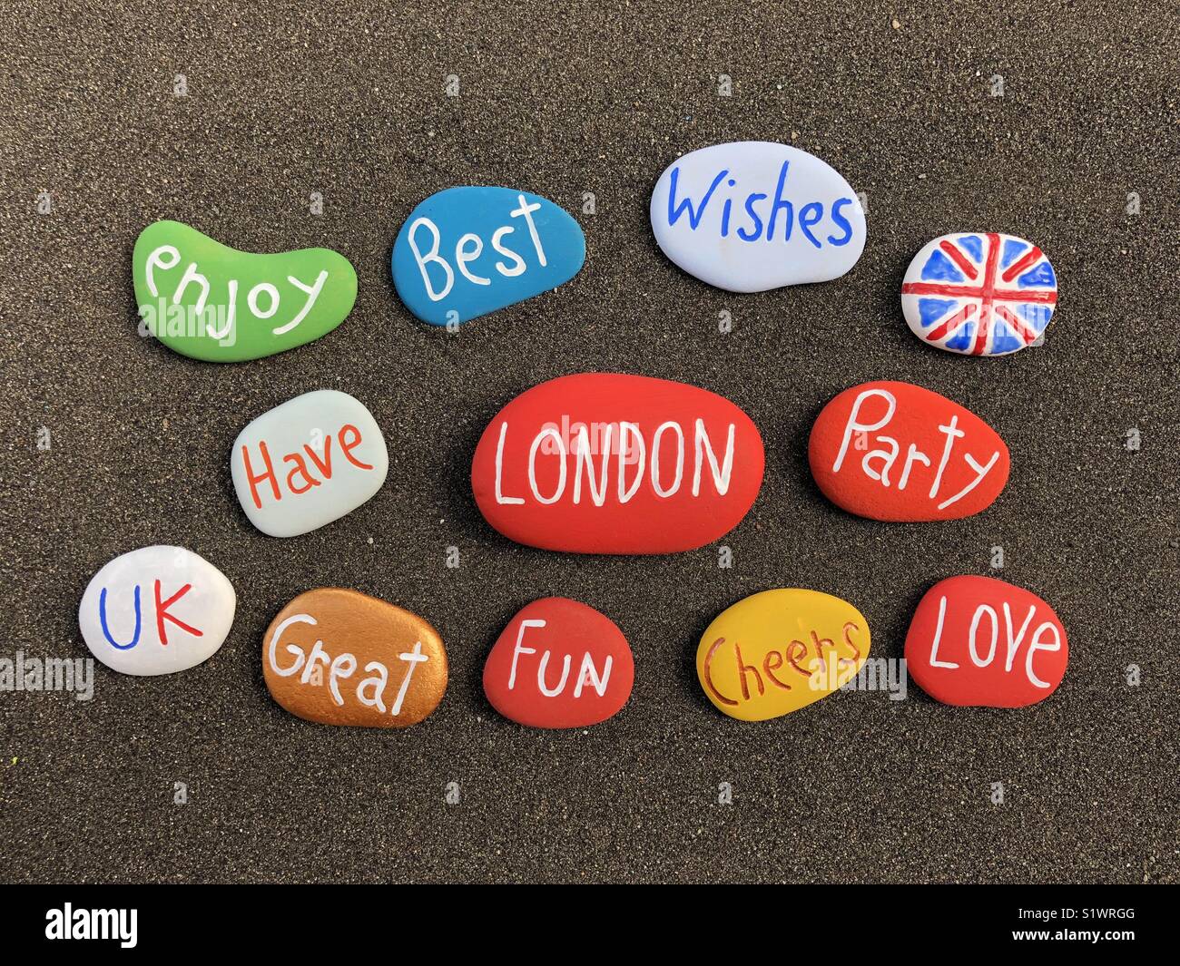 Best wishes from London with milticolored stones over black volcanic sand - Smartphone Captured Stock Image