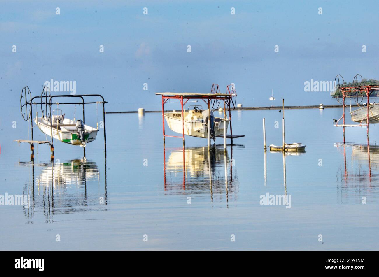 Fishing boats hanging out of the water on Bora-Bora, French Polynesia, South Pacific - Smartphone Captured Stock Image