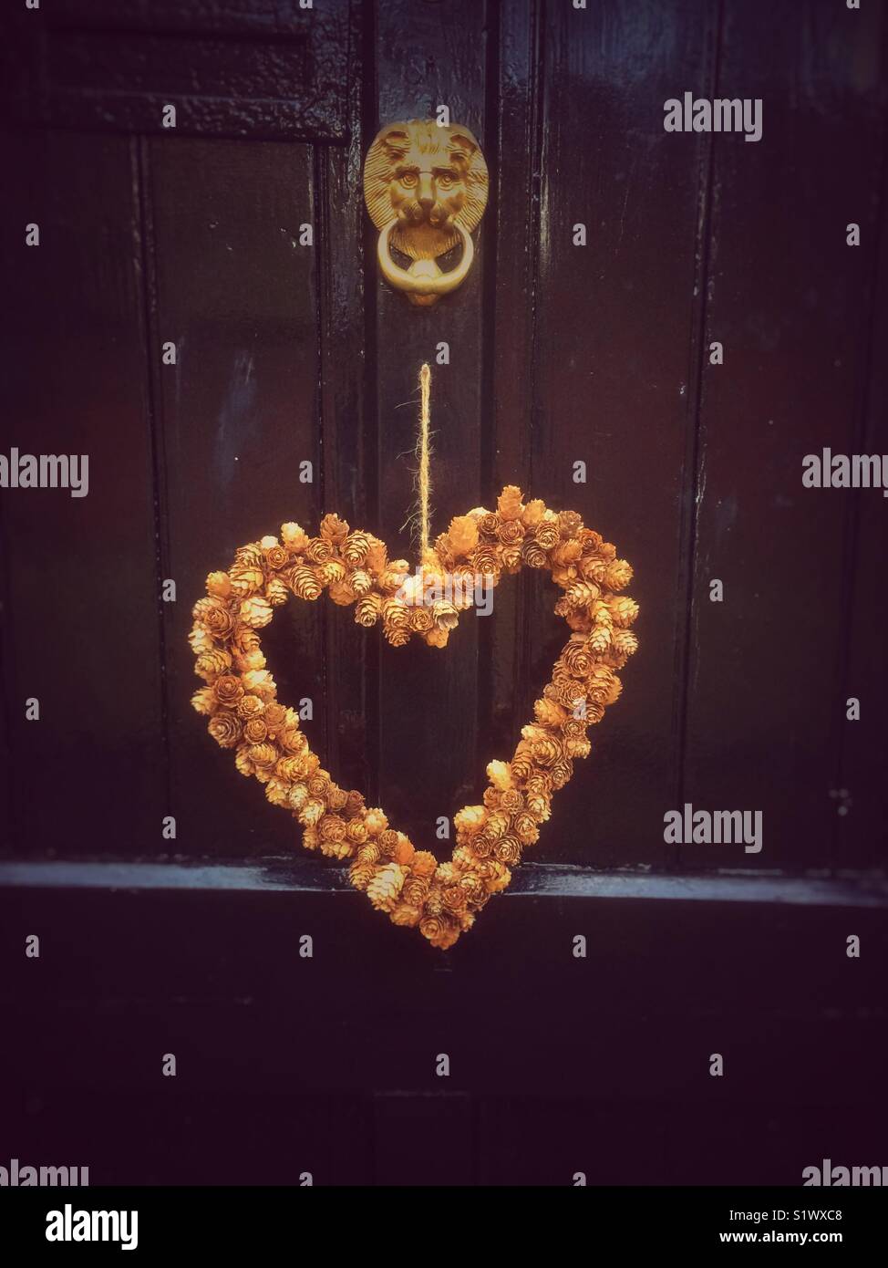 Heart shaped wreath hanging on door England UK United Kingdom GB Great Britain - Smartphone Captured Stock Image