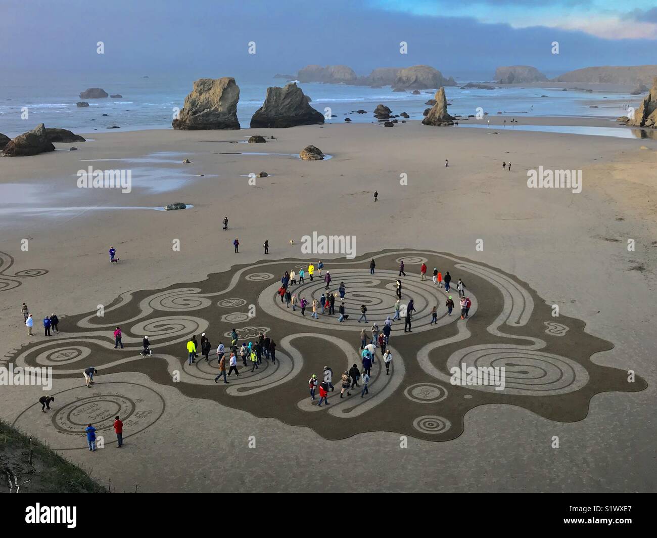 People walk on temporary labyrinth on Bandon Beach, Oregon - lasts only until next high tide Stock Photo