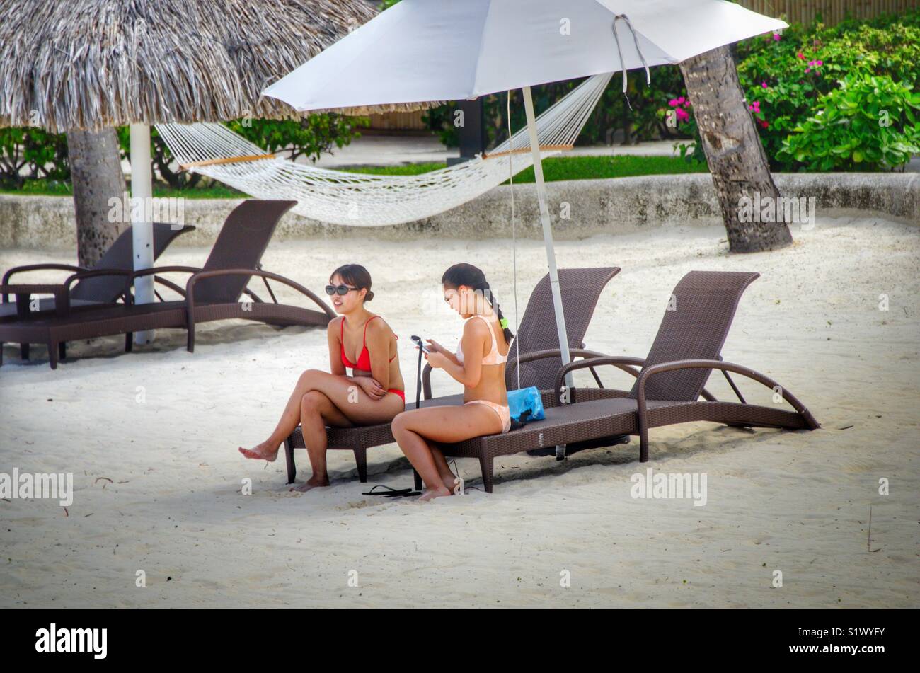 Women relaxing at the beach on the island of Bora-Bora, French Polynesia in the South Pacific - Smartphone Captured Stock Image