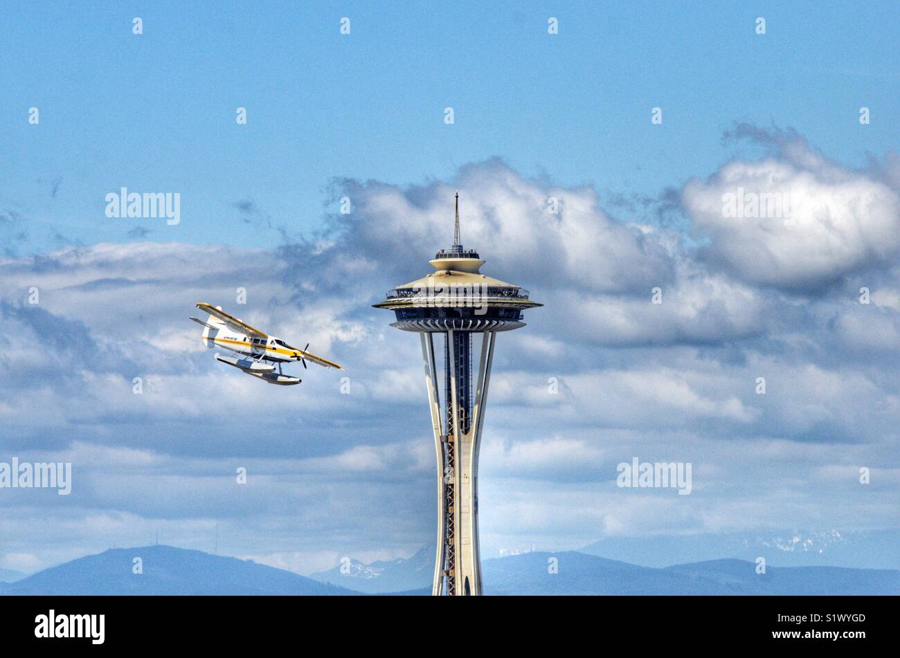 Seaplane from Kenmore air flying past the space needle in Seattle Washington on its approach to Lake Union - Smartphone Captured Stock Image