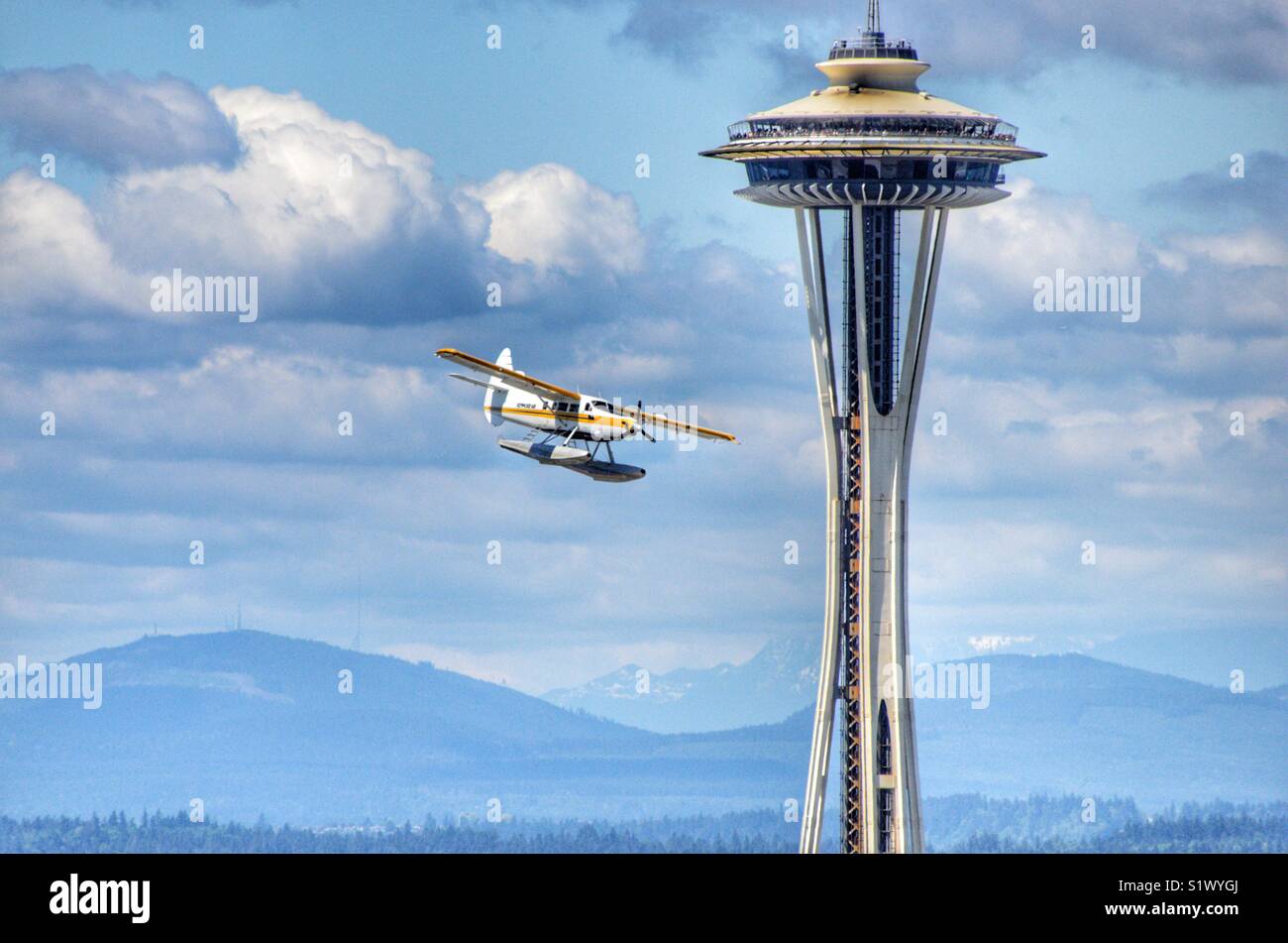 See playing from Kenmore air passing the space needle at a low altitude as it is landing at Lake Union in Seattle Washington - Smartphone Captured Stock Image