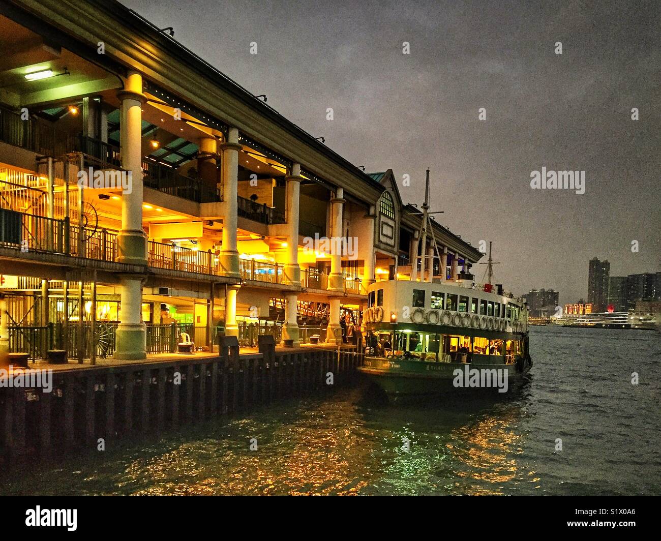A Star Ferry at Central Pier 7 on Hong Kong Island at dusk waits to take passengers across Victoria Harbour - Smartphone Captured Stock Image
