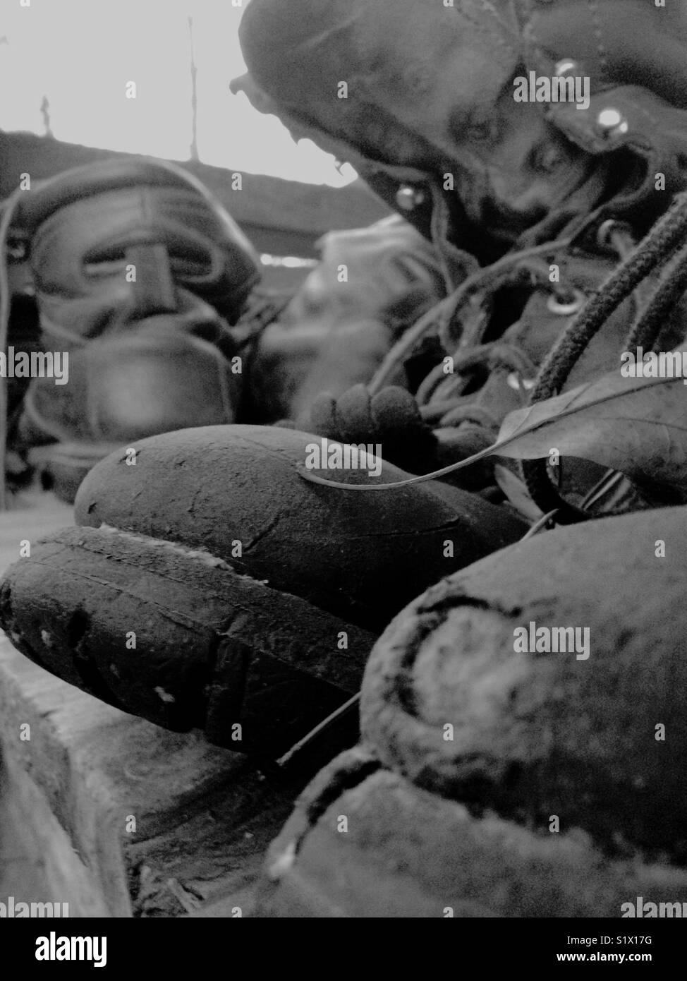 Black and white photo of old leather boots waiting for new life as planters - Smartphone Captured Stock Image