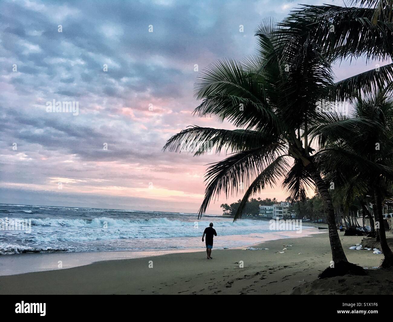 A person taking a stroll during sunrise on a beach in the Dominican Republic. Stock Photo