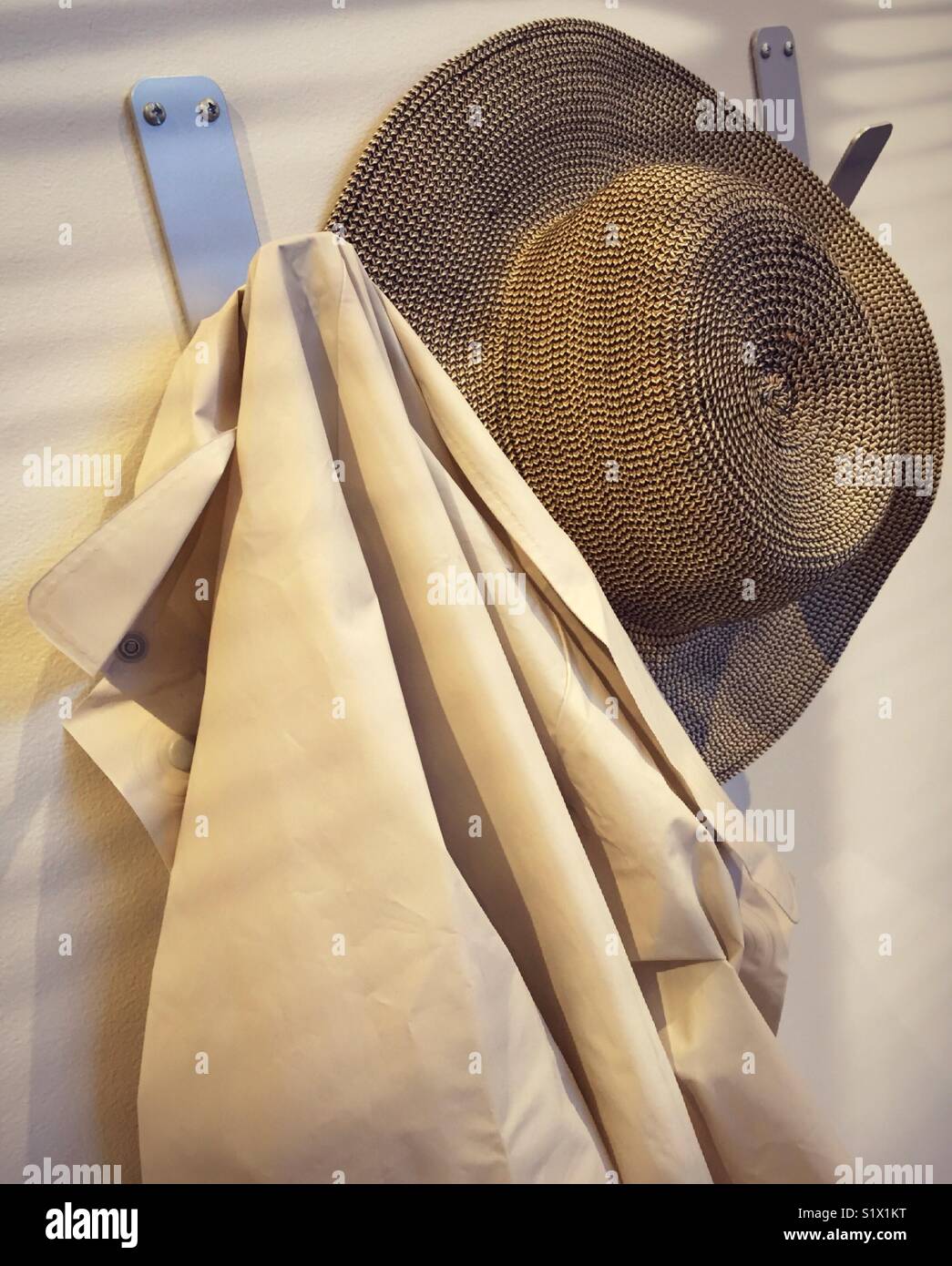 Hat and light jacket hanging on coat room pegs. - Smartphone Captured Stock Image