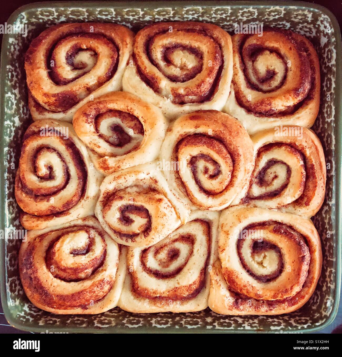 Square ceramic dish full of freshly baked cinnamon rolls - Smartphone Captured Stock Image
