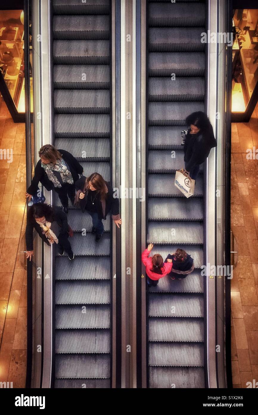 Groups of People taking an escalator in a mall. Shot taken from above. Strasbourg, France. - Smartphone Captured Stock Image