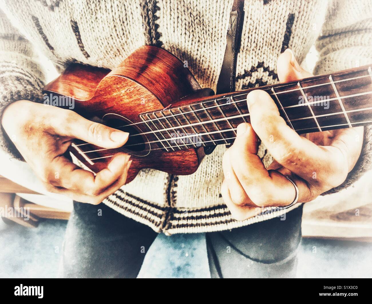 Woman playing a soprano ukulele, high angle view. - Smartphone Captured Stock Image