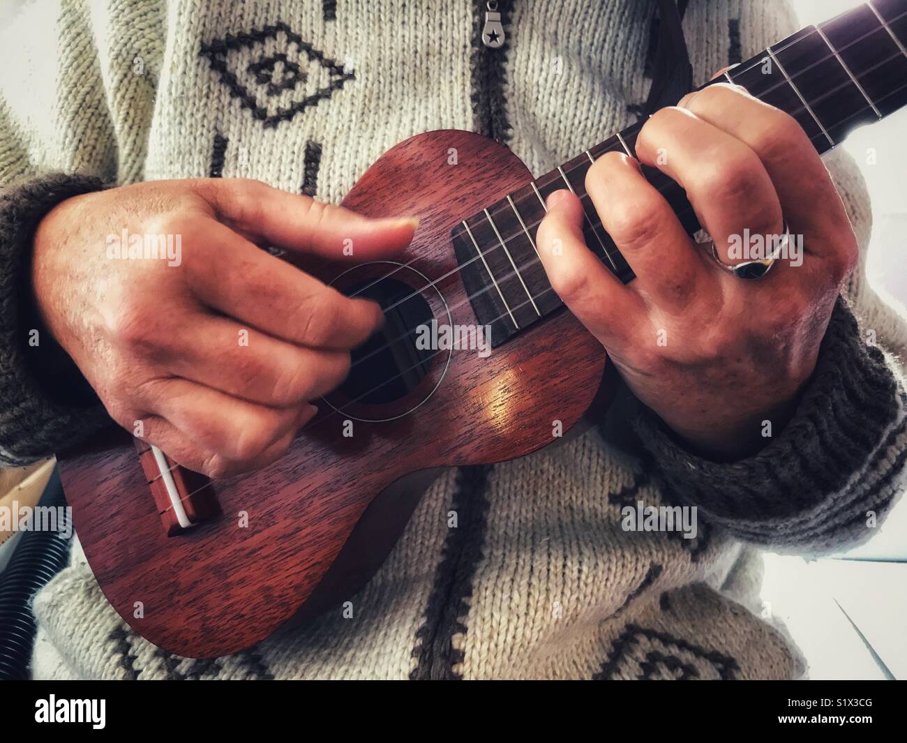 Woman playing a soprano ukulele, close up - Smartphone Captured Stock Image